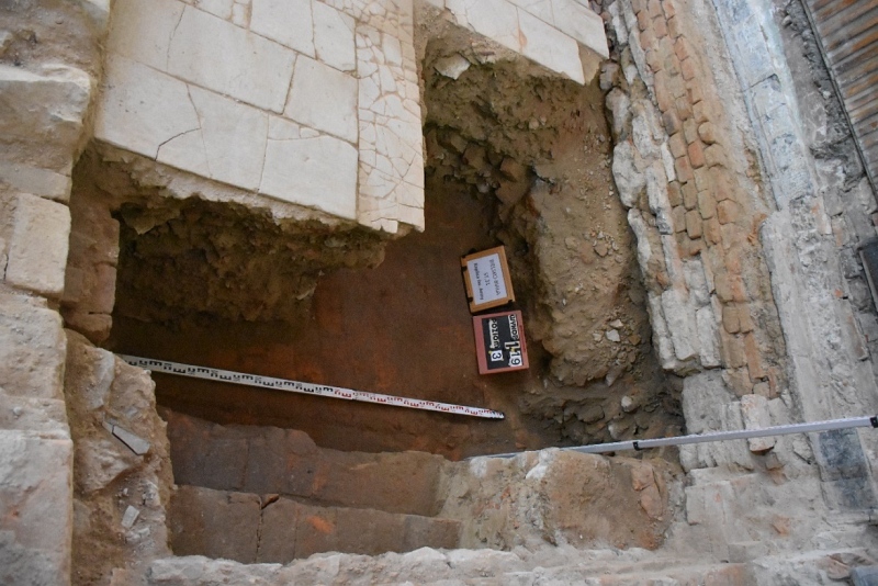 Fotografia z góry ukazująca fragment odsłoniętej w wykopie badawczym ceglanej posadzki piwnicy  baszty oraz stopnie schodów zejściowych prowadzących do niej od strony wschodniej (obecnie tarasów zamkowych).